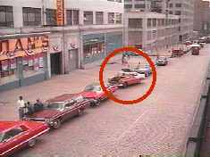 Wilkersons car (in circle) parks on the right side of the street, clearly facing a block of stores.