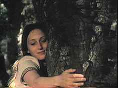 Our goofy heroine actually (No! Yes!!) hugs a tree (!!!!!).