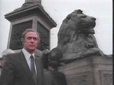 The expressive Michael Caine is seen here sitting on a pedestal, while... oh, wait. Thats a stone lion. Caines on the left.